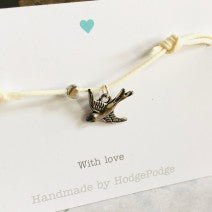 Adjustable cord bracelet with bird charm (cream)