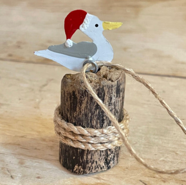 Seagull in a Santa hat on groyne hanging Christmas decoration by Shoeless Joe