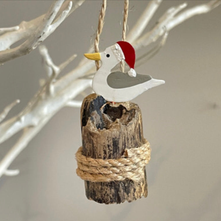 Seagull in a Santa hat on groyne hanging Christmas decoration by Shoeless Joe