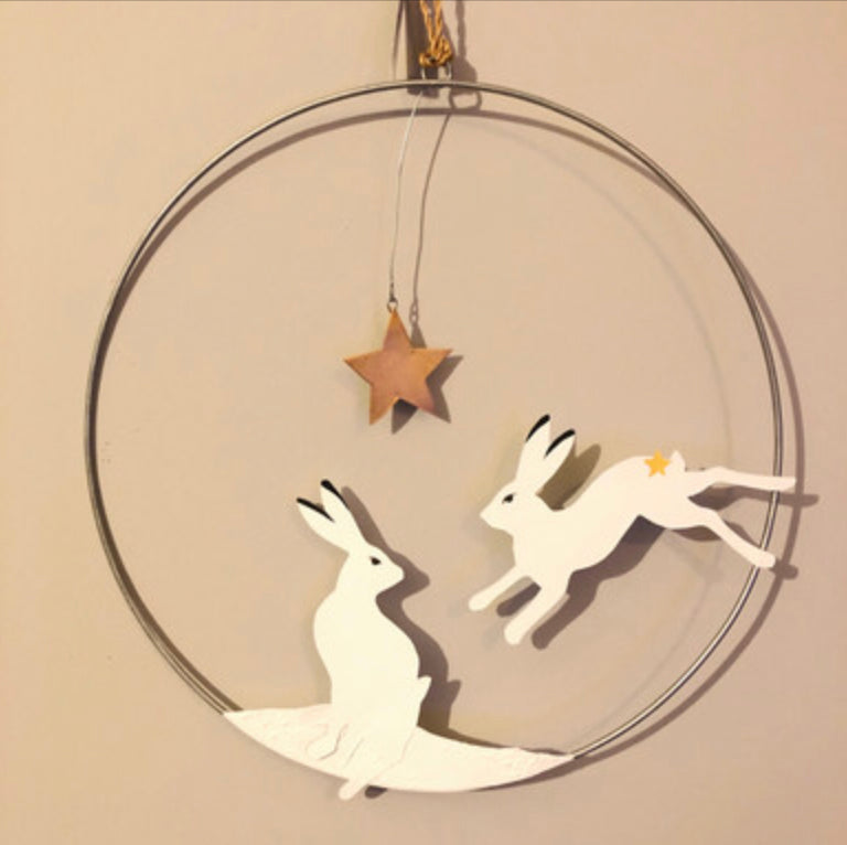 Artic hare hanging Christmas wreath by Shoeless Joe