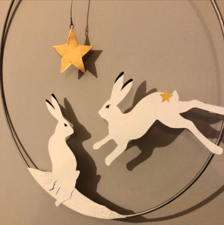 Artic hare hanging Christmas wreath by Shoeless Joe